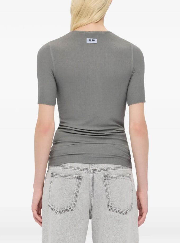 Camiseta de punto acanalado de viscosa suave con cuello redondo y mangas cortas, bordes sin rematar y etiqueta MSGM en la espalda. Corte ajustado. La modelo lleva una talla S/40.
